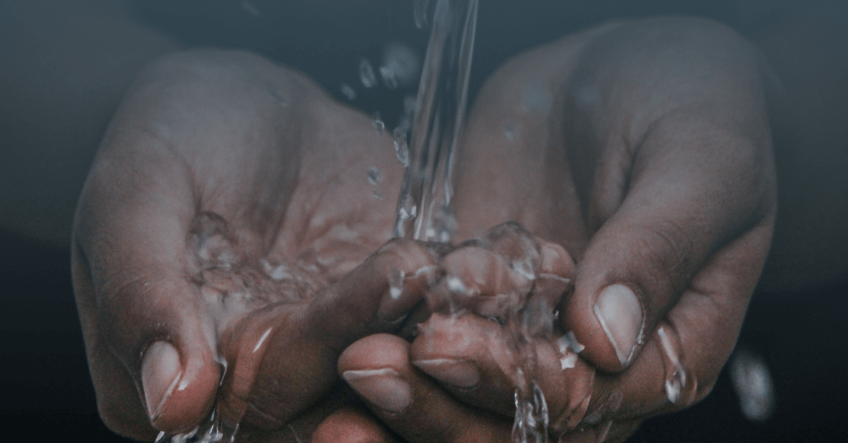 fotografia mostra close de mãos em concha sob jato de água para representar a importância do saneamento em tempos de pandemia