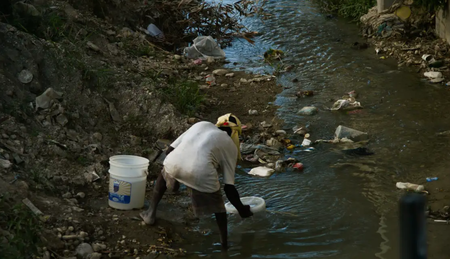 Mulher pega água do esgoto em Porto Príncipe, capital do Haiti (Marcello Casal Jr./Agência Brasil)